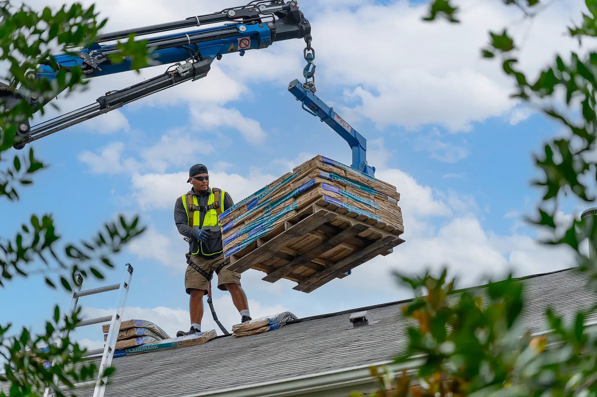 Roofing installers delivering shingles to the roof surface
