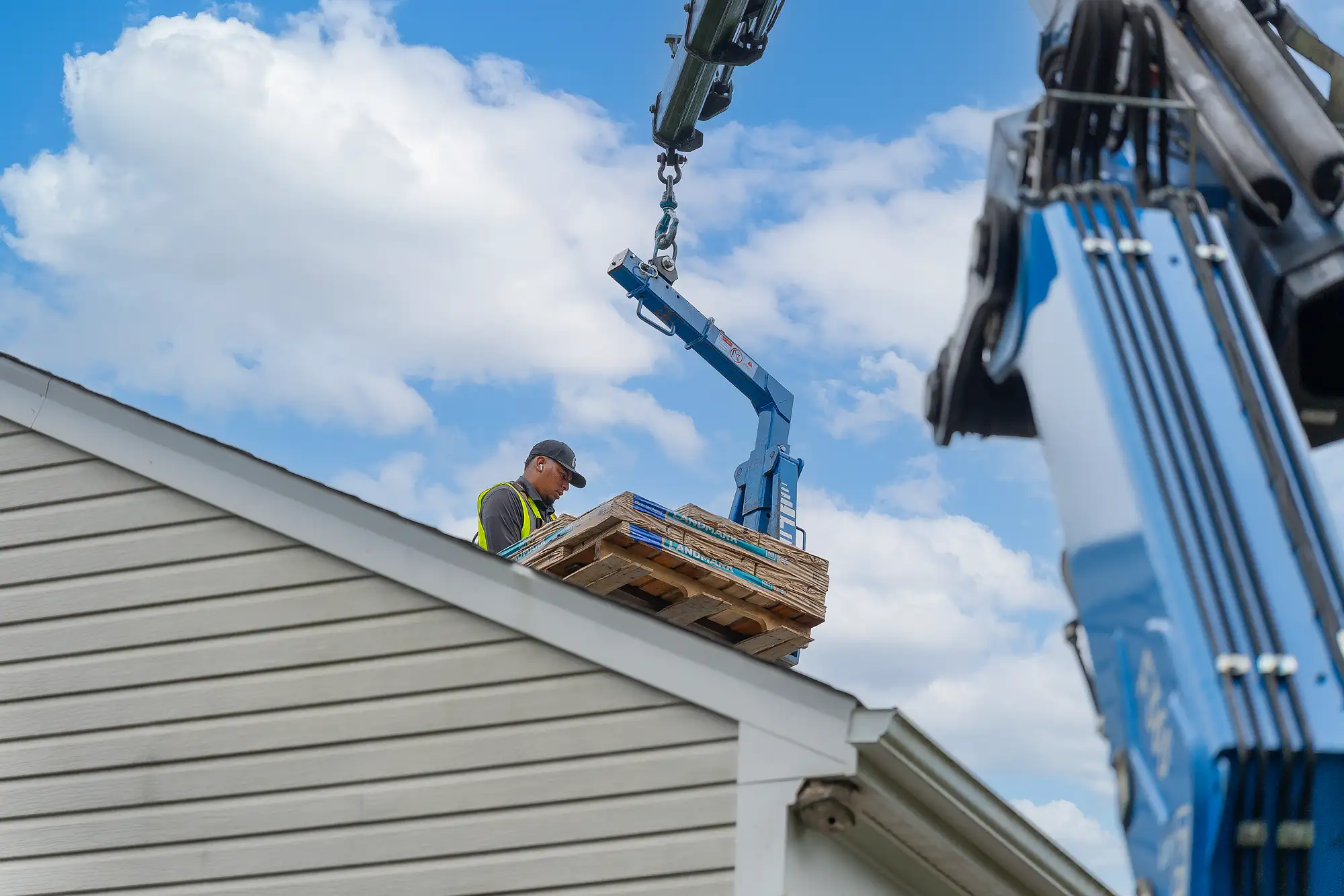 Contractors carrying roofing bundles during a residential roofing project
